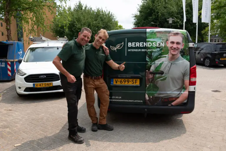 Tom Berendsen en collega voor bus van Berendsen Interieurbeplanting met bedrijfslogo en plantenafbeelding