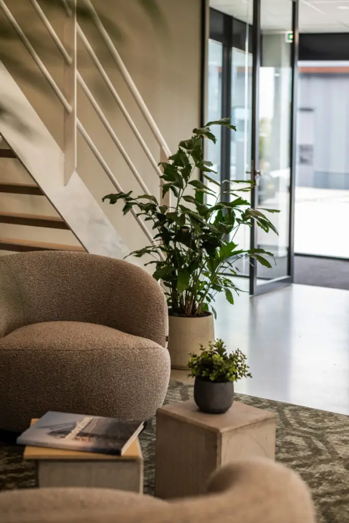 Sfeervolle entree met compacte palmen in beige potten – een warme, uitnodigende uitstraling voor bezoekers.